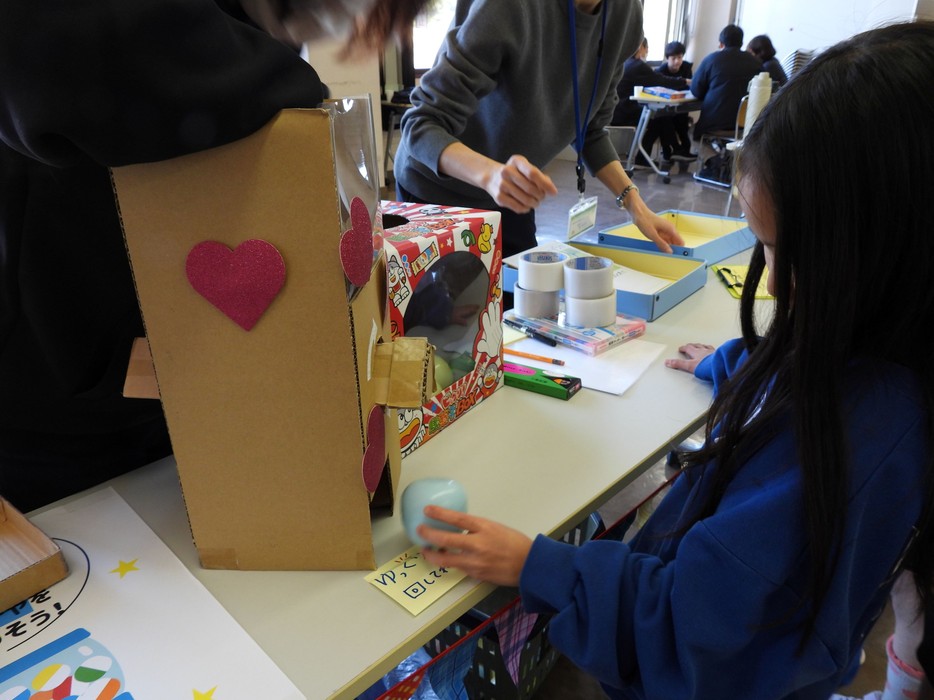 アンケートに答えガチャを回す子どもたち